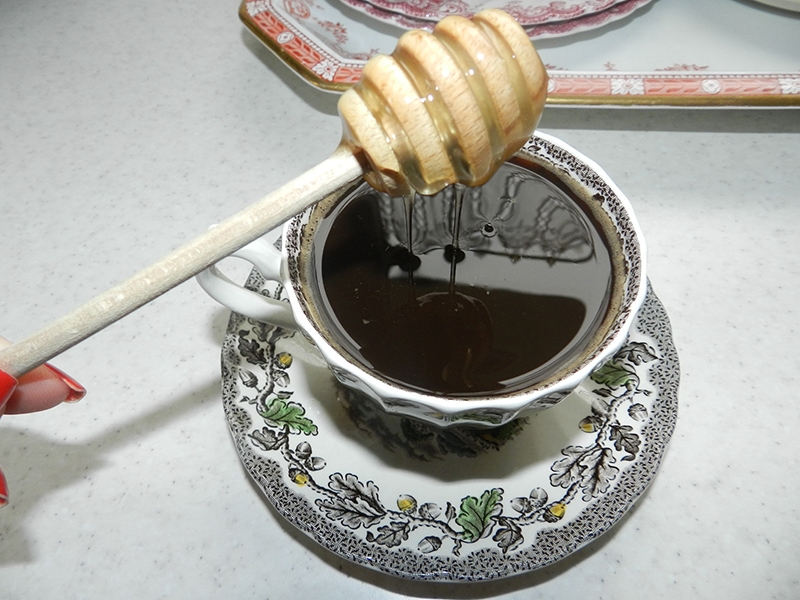 putting honey on a cup of coffee