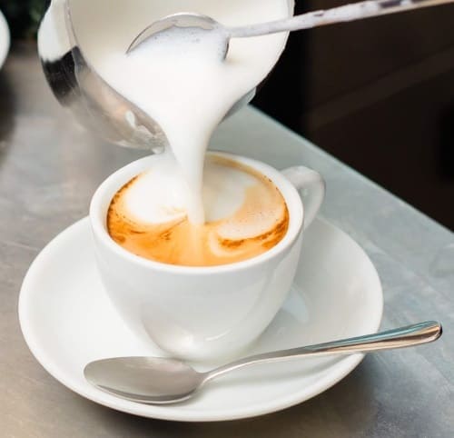 steamed milk being poured from the pitcher