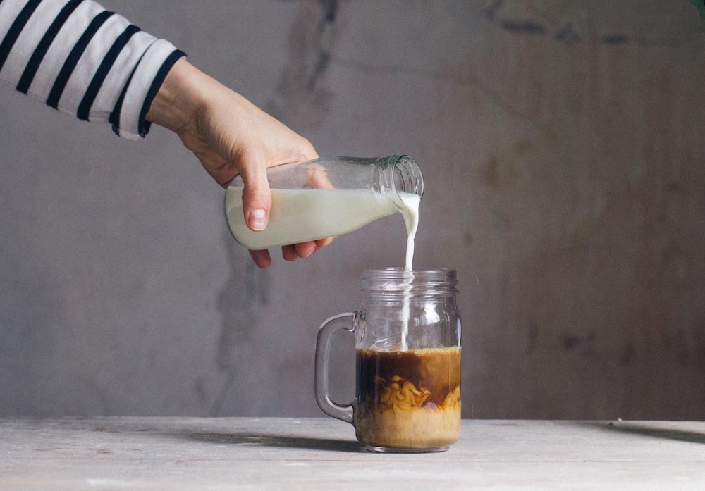 Pouring cream into coffee