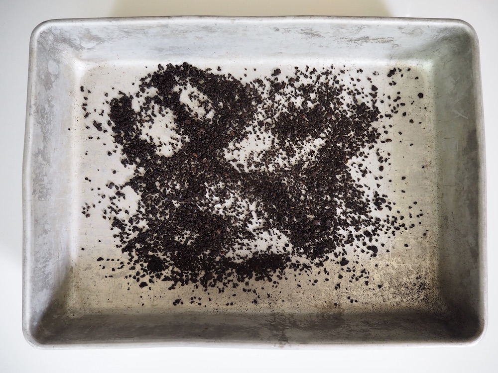 Spread coffee grounds on baking sheet