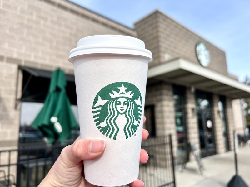 Starbucks hot drink in paper cup in front of cafe