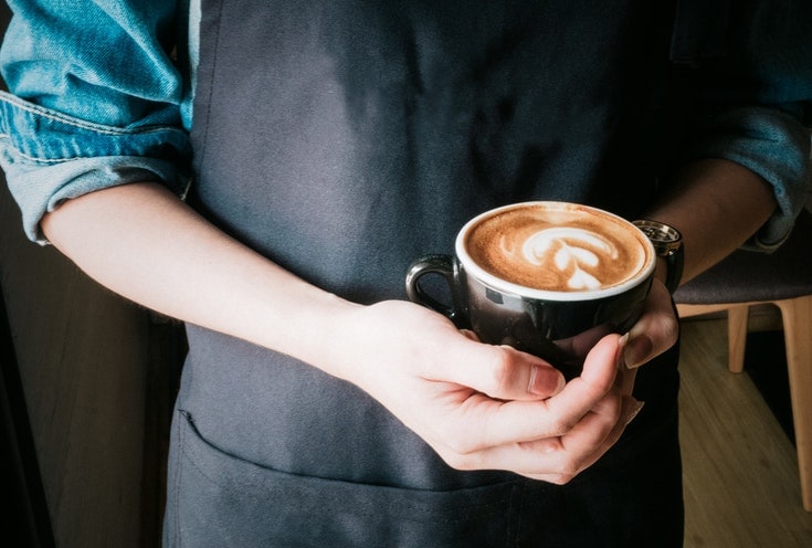 Barista holding a cup of coffee