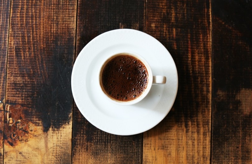 a cup of coffee on a wooden table