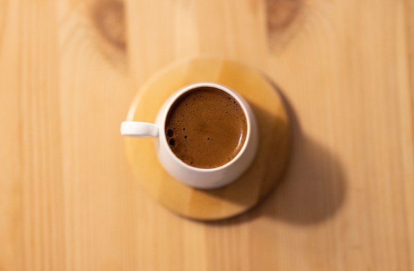 a cup of coffee on wooden table