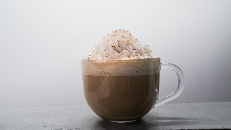 a glass of coffee with whipped cream