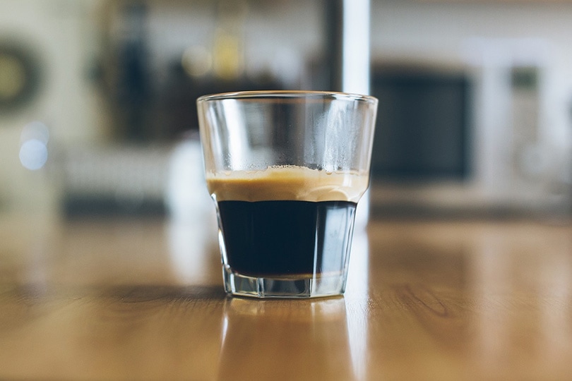 a glass of espresso on a laminated table