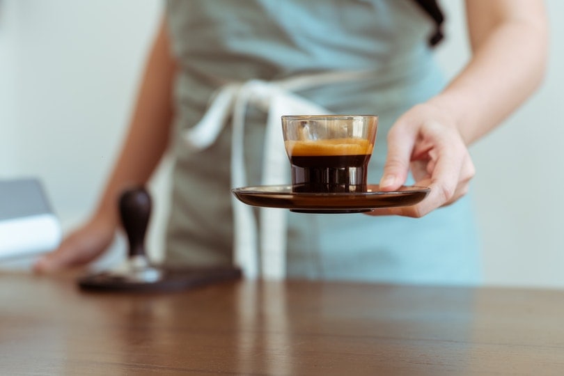 barista with fresh black coffee ready for customer