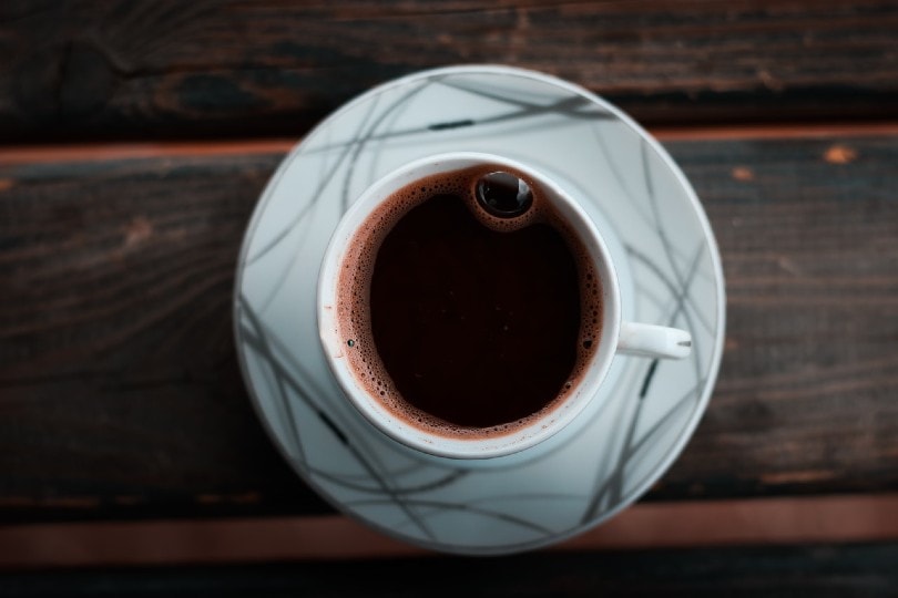 black coffee in a white ceramic cup with saucer