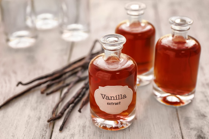 bottles of vanilla extract and dry vanilla beans on table