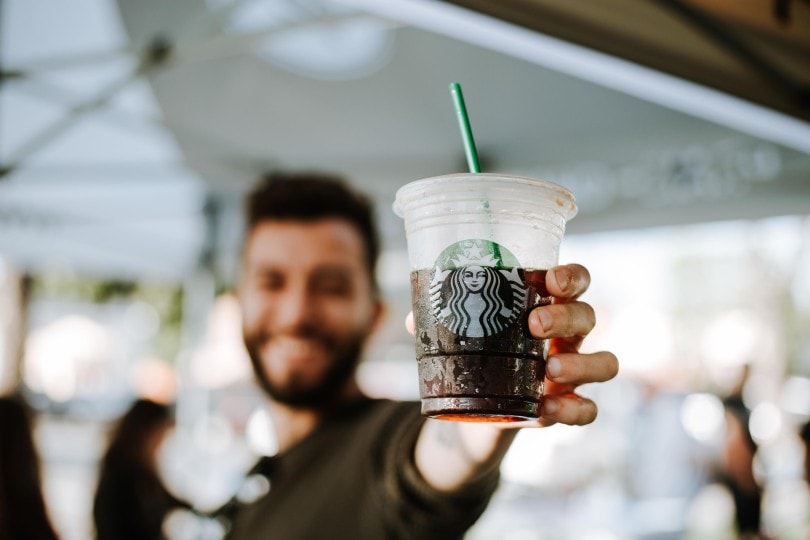 man holding a starbucks drink