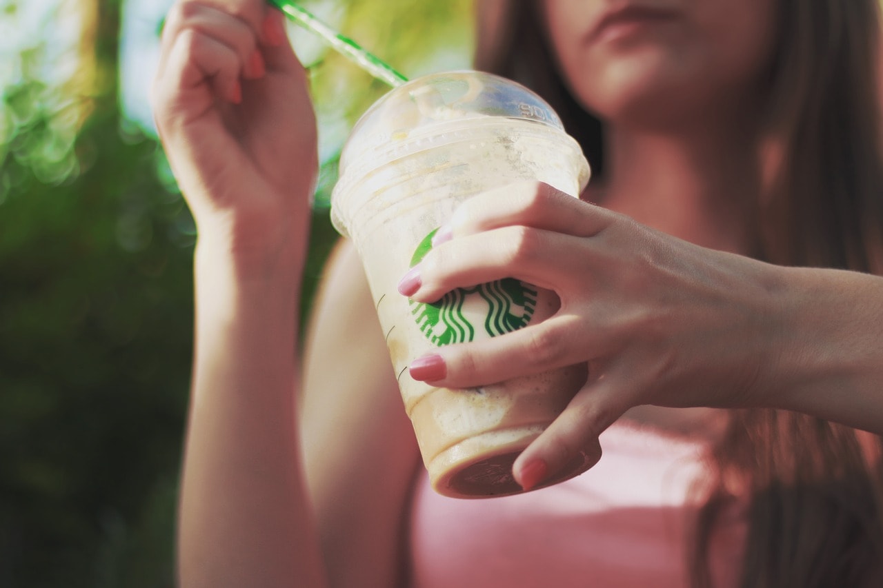 person holding a starbucks drink