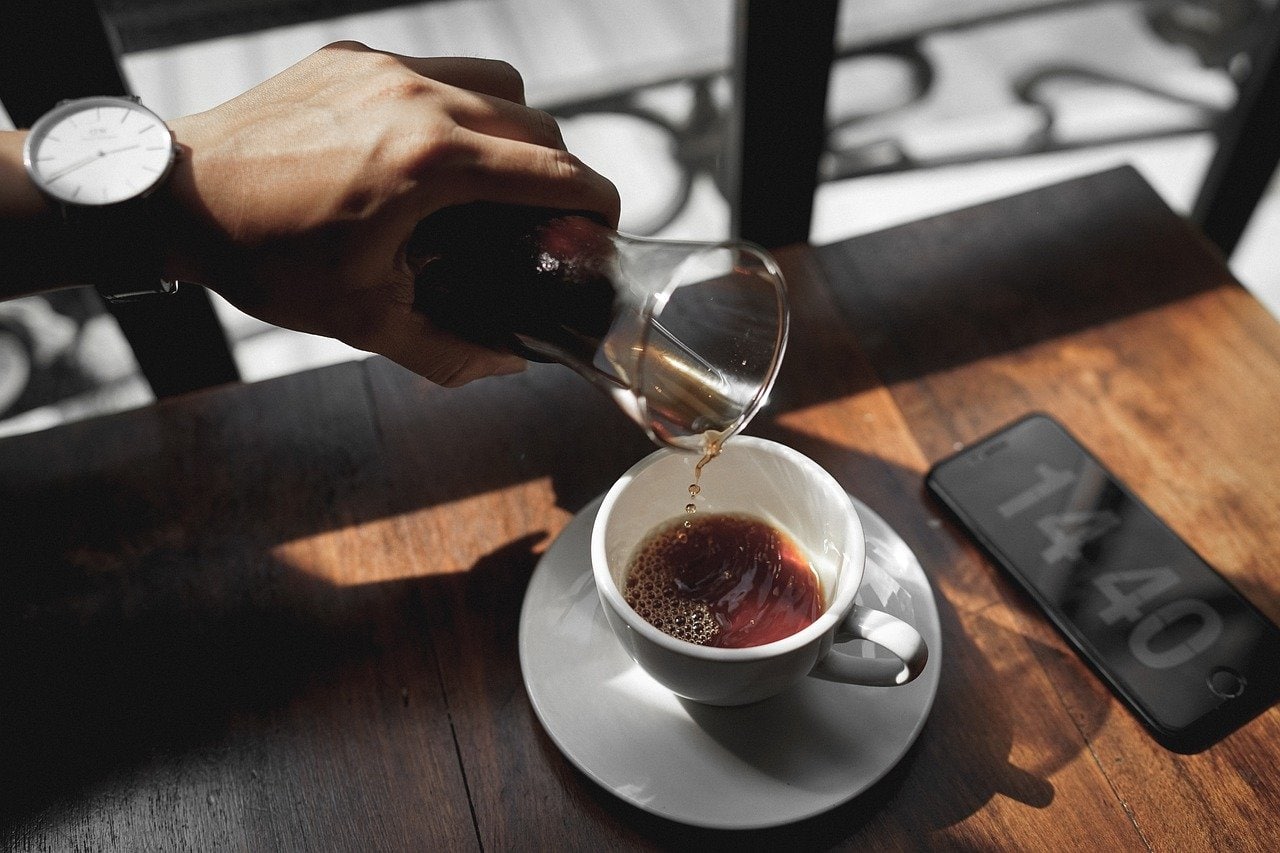 pouring brewed coffee on a cup