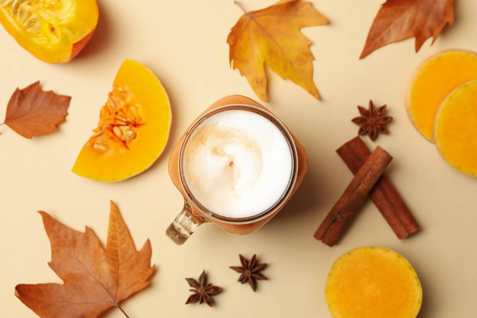 pumpkin spice latte surrounded with cinnamon and leaves