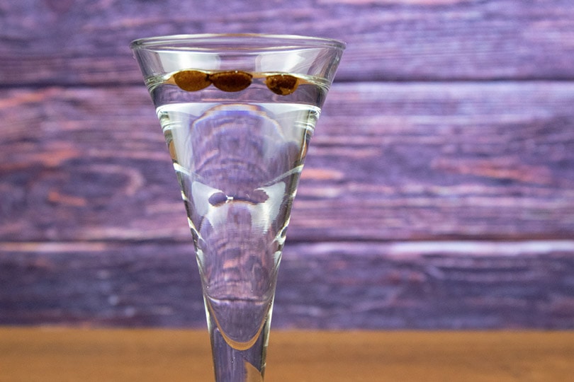 a glass of Sambuca with three coffee beans