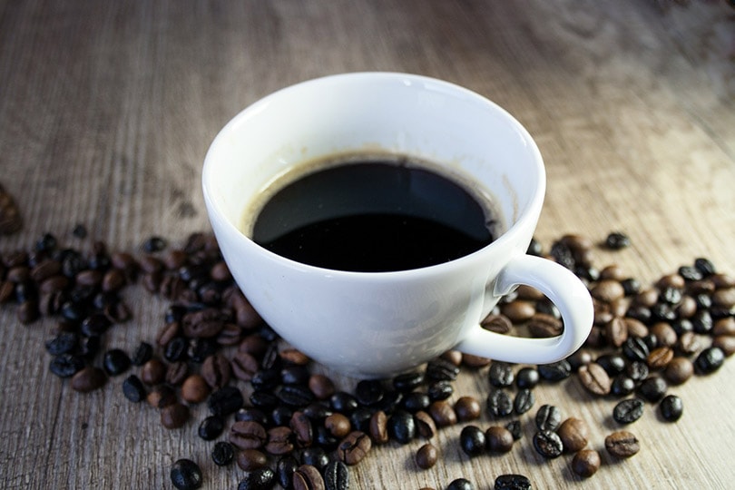 coffee in a white cup with coffee beans