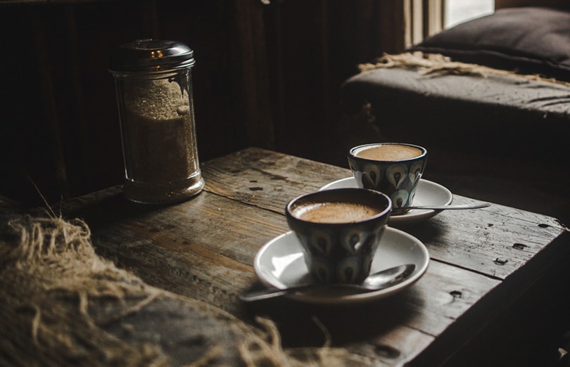 cortado coffees in coffee cups on a wooden table in a cozy rustic Guatemalan café