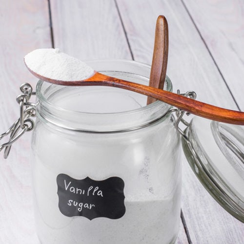 Teaspoon vanilla sugar placed on a glass jar with vanilla sugar