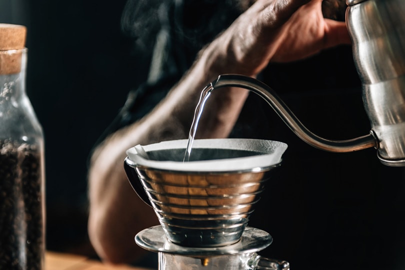 close up of a barista pouring boiling water into Kalita Wave Dripper to brew coffee