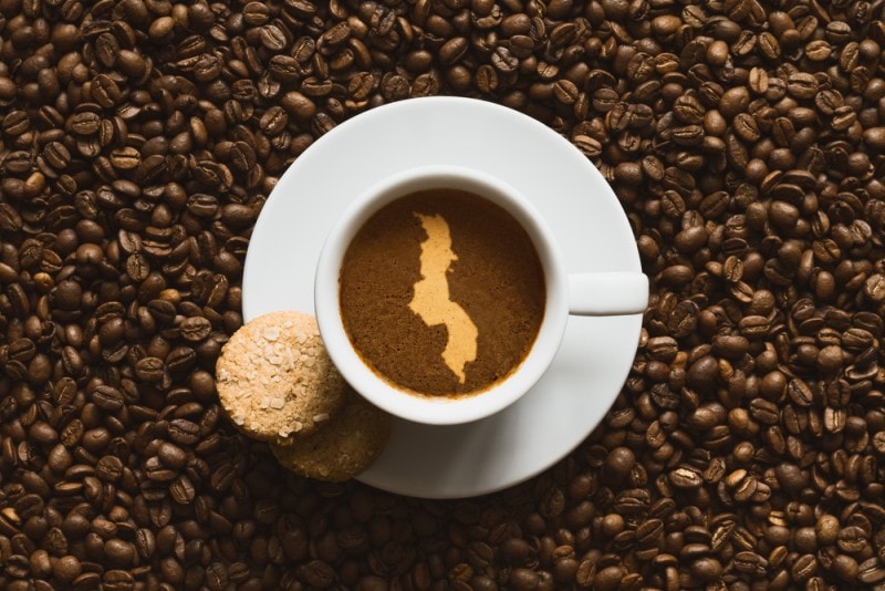 Malawi map in coffee cup with beans and cookies
