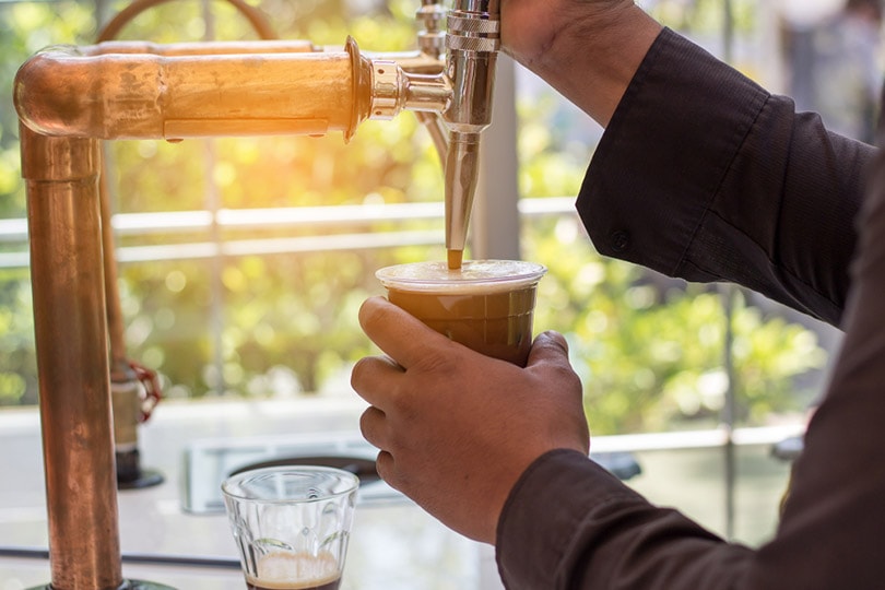 cropped barista making nitro cold brew coffee in the cafe