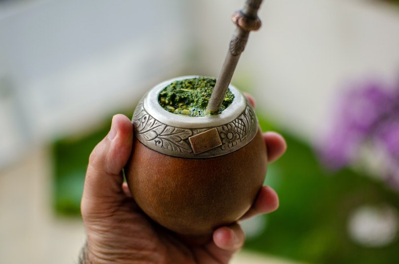 hand holding a yerba mate in wooden gourd