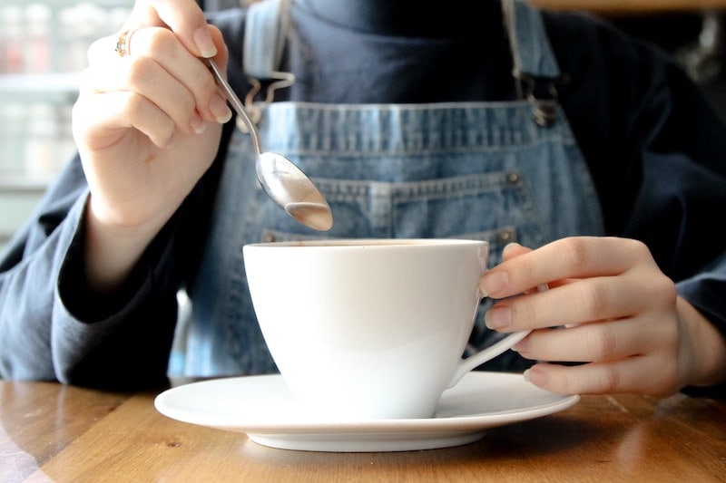 stirring coffee in cup with spoon