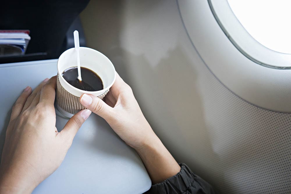 woman holding her airplane coffee