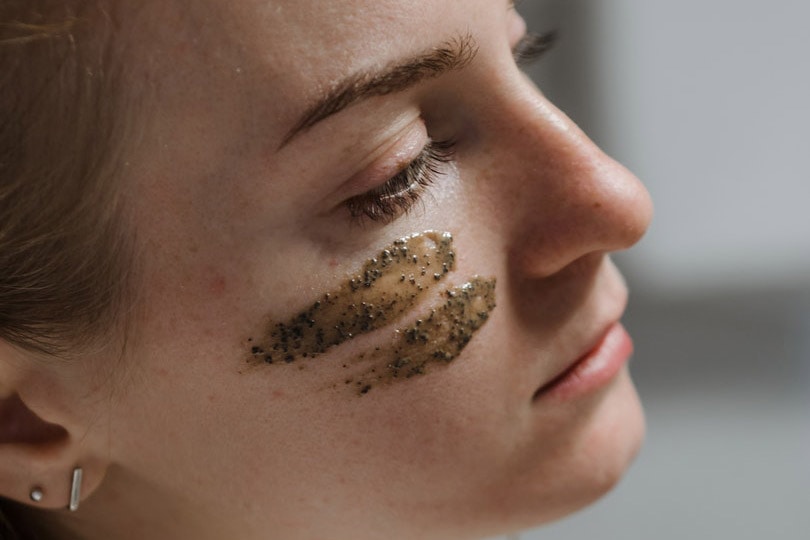 woman with coffee scrub on face