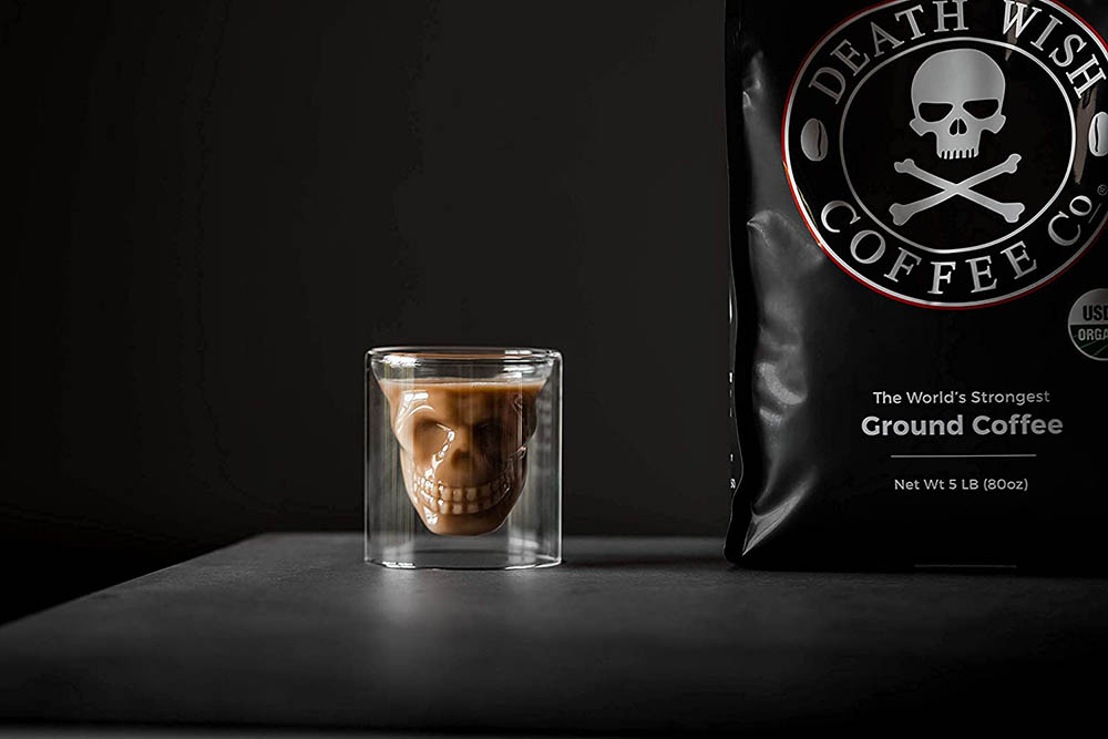DEATH WISH COFFEE Dark Roast Coffee Grounds and a cup of coffee