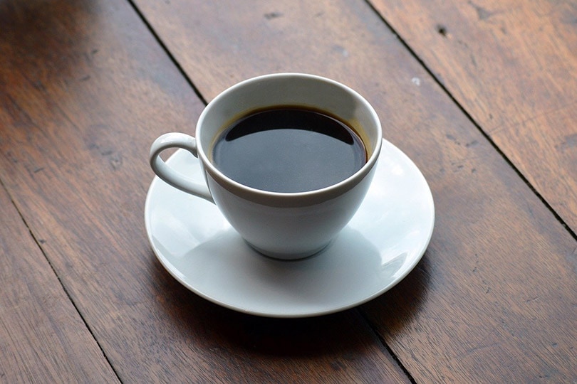 a cup of Americano on wooden table