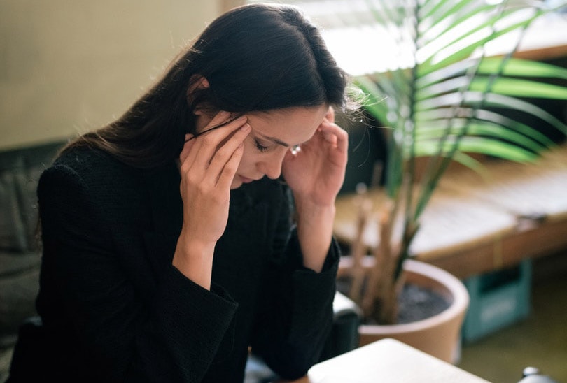 a woman at work massaging her head