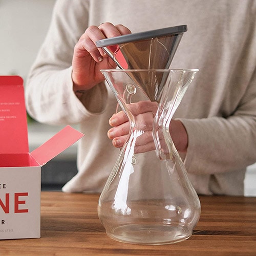 cropped woman holding kone coffee filter and chemex