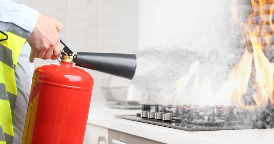 fire extinguisher spraying on fire in kitchen