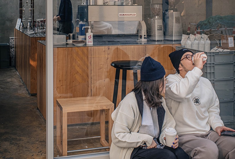 male and female drinking coffee outside a coffee shop in China