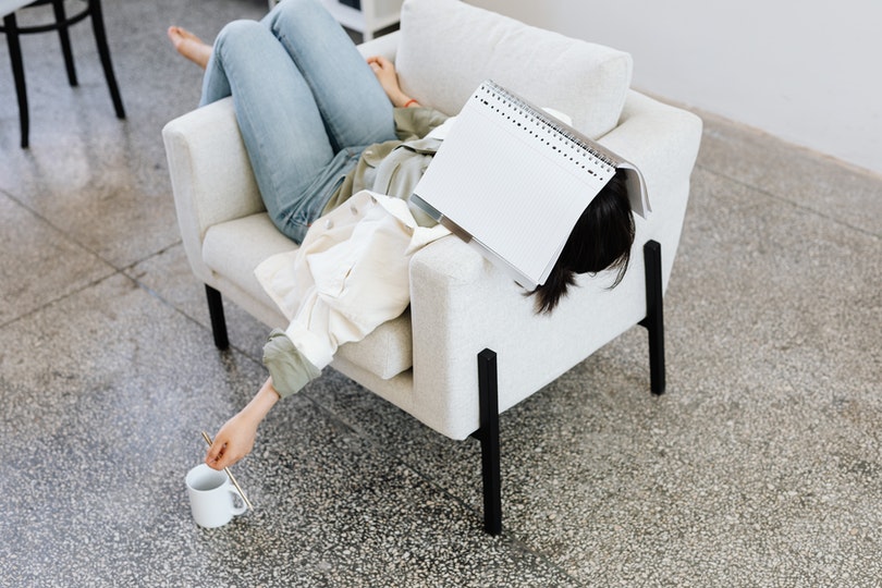 woman sleeping on sofa near a cup of coffee