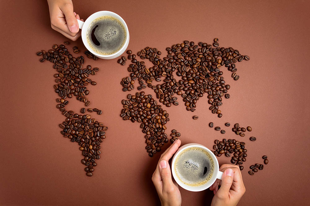 world map made of coffee beans and persons holding coffee