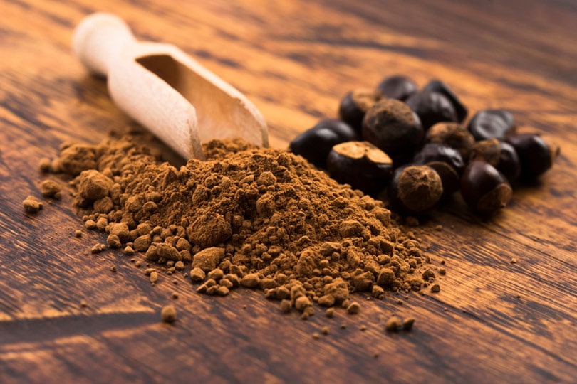 Guarana seeds and powder on wooden surface