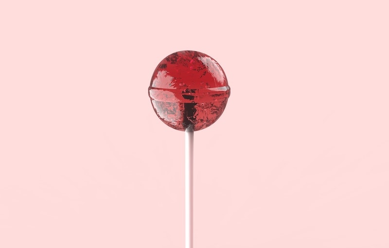 caffeinated maple bacon lollipop on pink background