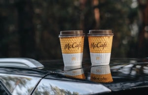 two cups of mccafe drinks above the car