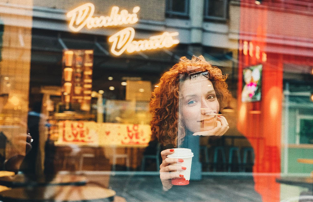 woman smiling holding a cup of Dunkin drink