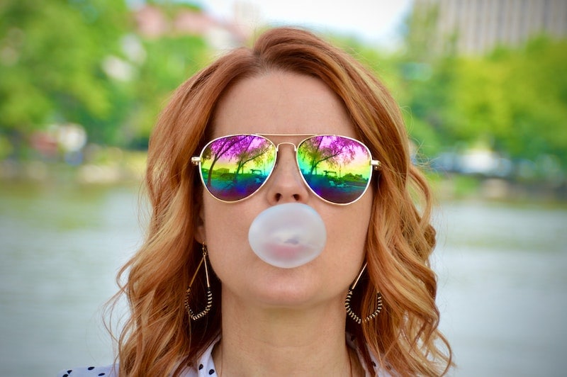 woman with sunglasses chewing gum