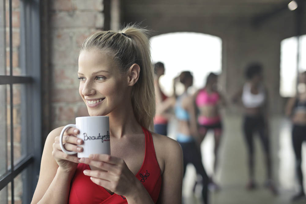 young woman having coffee after workout
