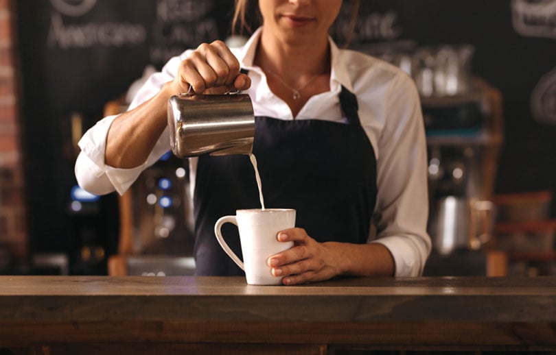 žena barista robí šálku kávy