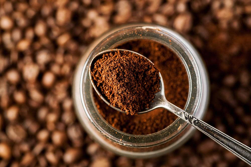 a spoonful of coffee grounds from a jar