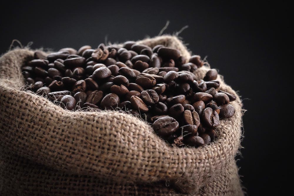 whole coffee beans in a burlap sack