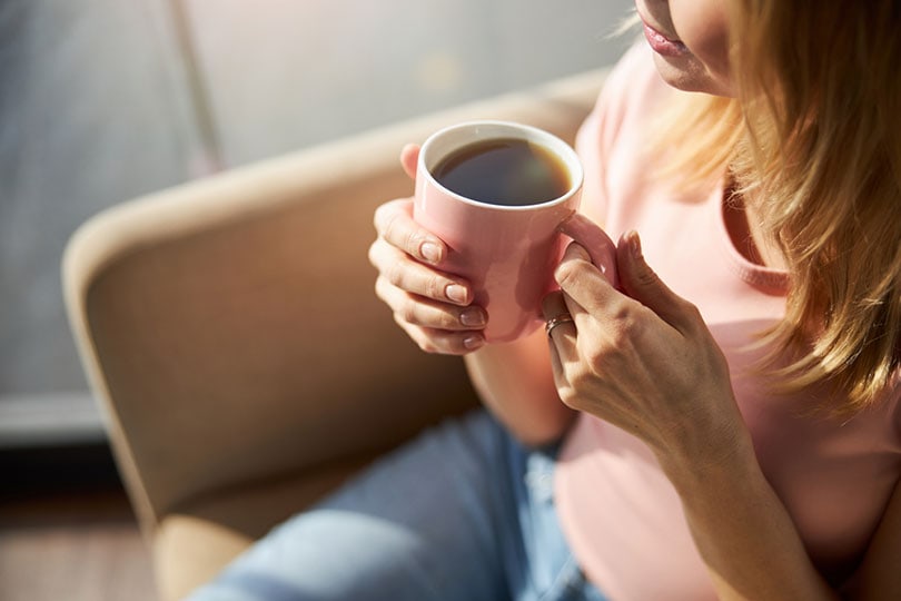 woman holding a pink cup of coffee