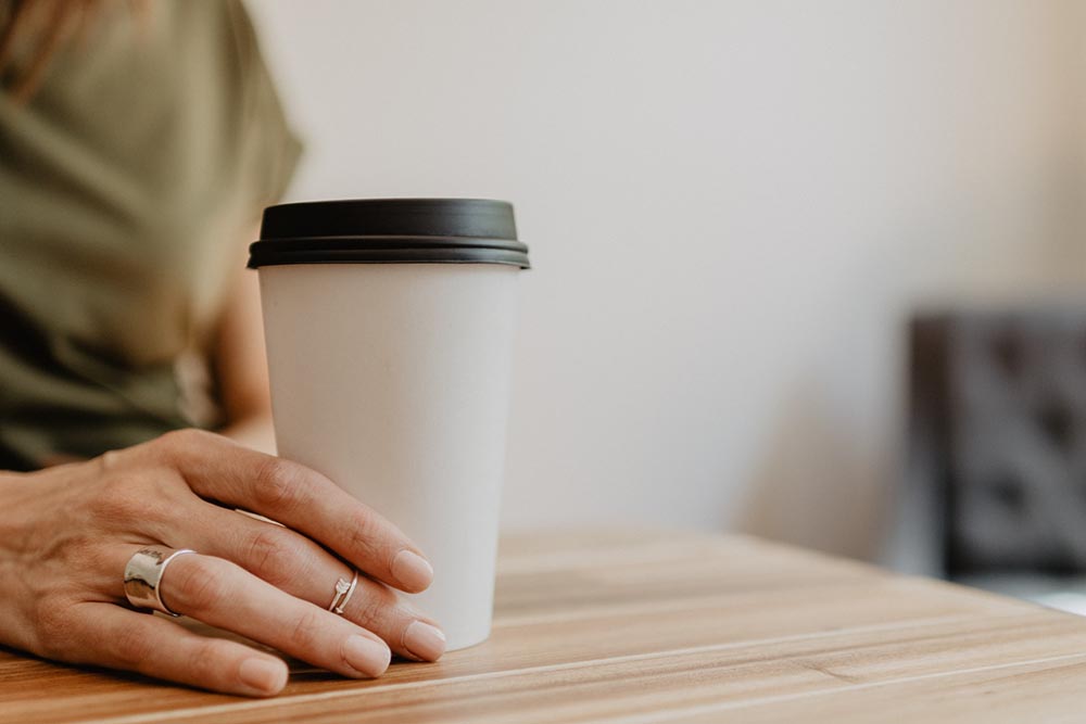 close-up mulher segurando uma xícara de café