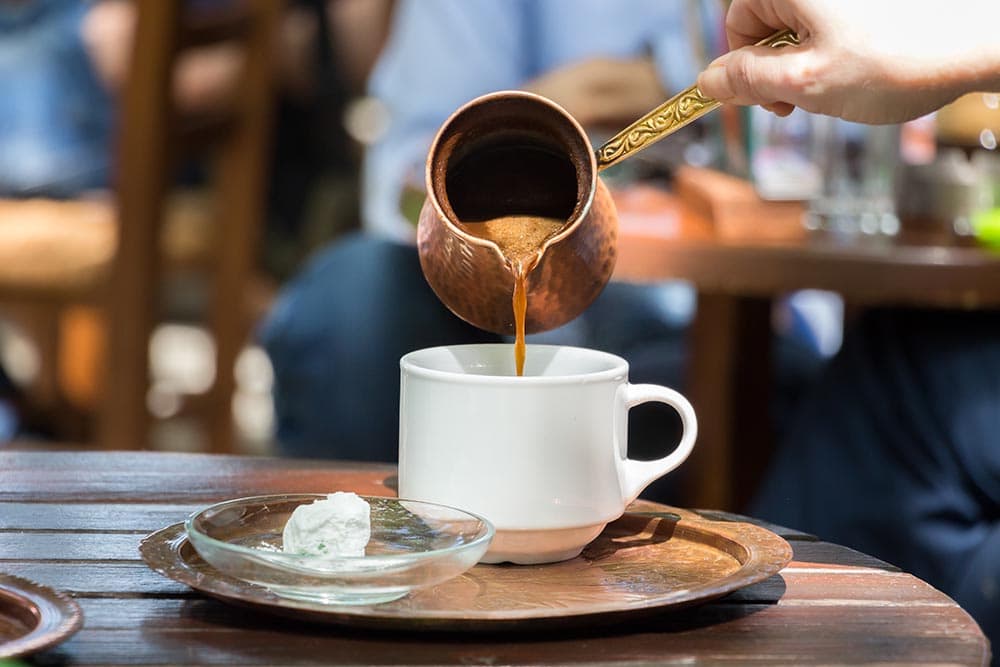 pouring greek coffee to a cup