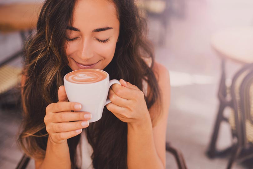 woman enjoying cappuccino in a cafe