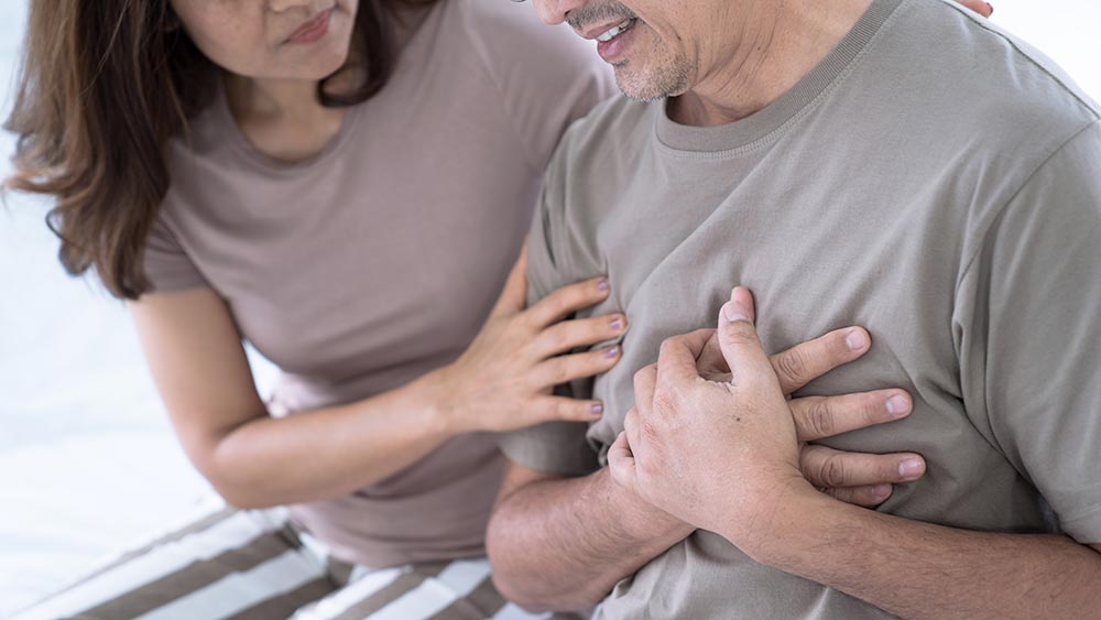 worried woman beside a man with chest pain